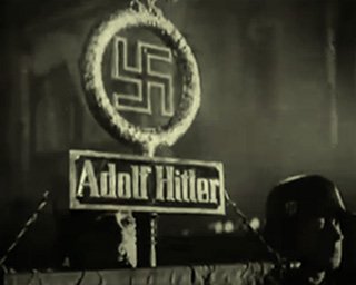SS soldiers holding aloft a Nazi Adolf Hitler banner during a night parade, in the lead up to World War Two in 1938.